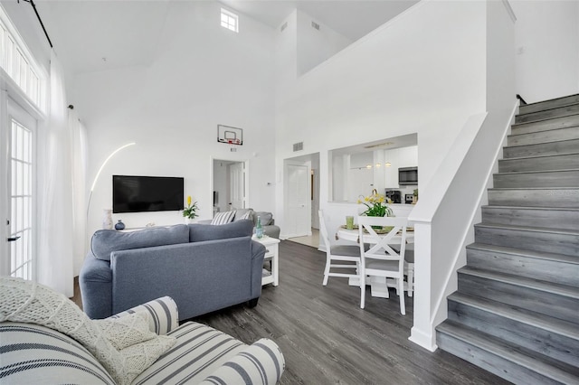 living room with dark wood-type flooring and a high ceiling