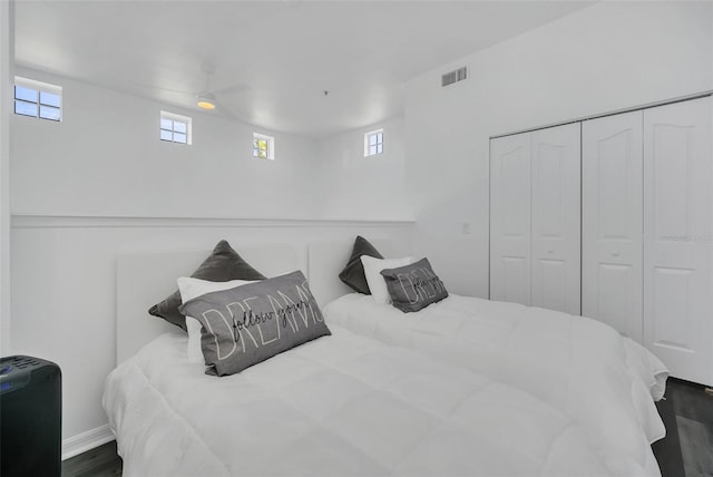 bedroom featuring a closet, dark hardwood / wood-style flooring, and ceiling fan