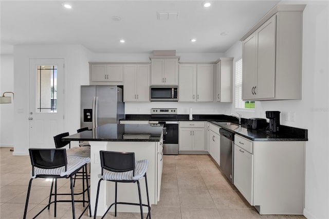 kitchen featuring a kitchen island, appliances with stainless steel finishes, sink, and a healthy amount of sunlight