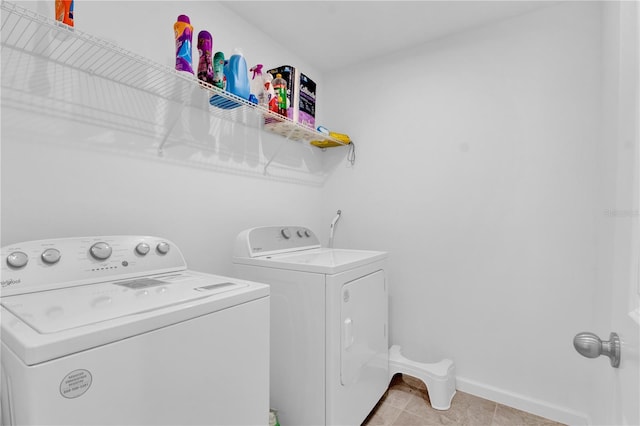 laundry area with light tile patterned floors and washing machine and clothes dryer