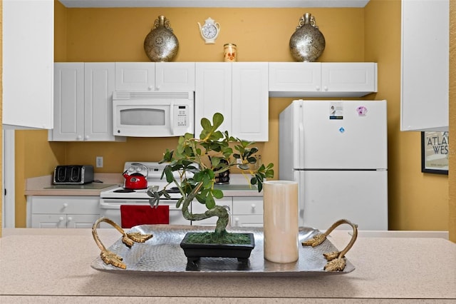 kitchen featuring white cabinets and white appliances