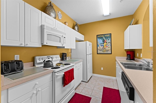 kitchen with light tile patterned floors, white appliances, white cabinetry, and sink