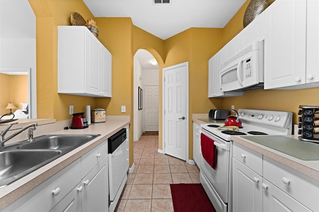 kitchen featuring white cabinetry, light tile patterned floors, white appliances, and sink