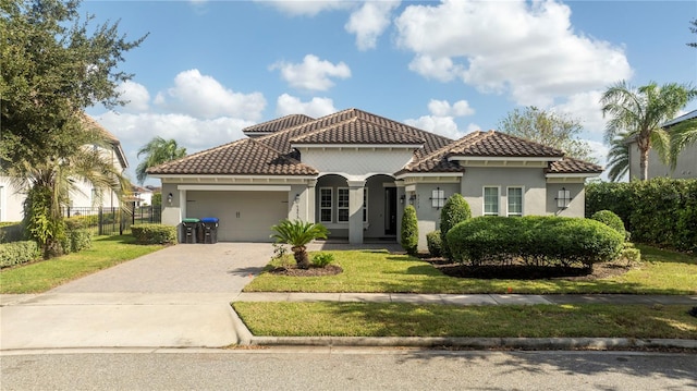 mediterranean / spanish house with a front yard and a garage