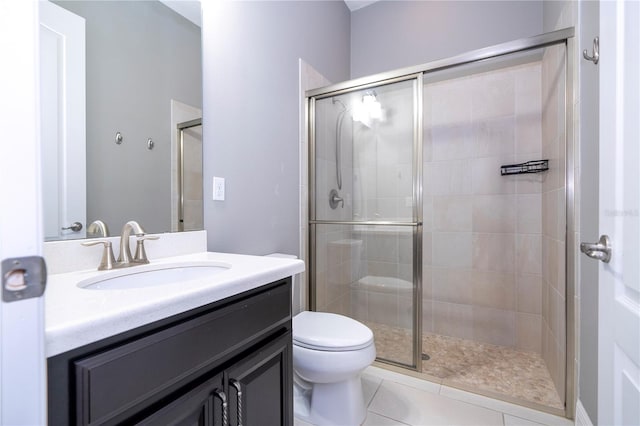 bathroom featuring toilet, tile patterned flooring, vanity, and walk in shower