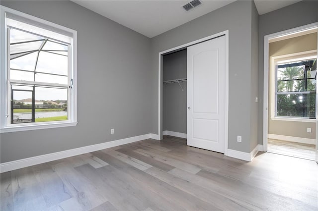 unfurnished bedroom with a closet and light hardwood / wood-style floors