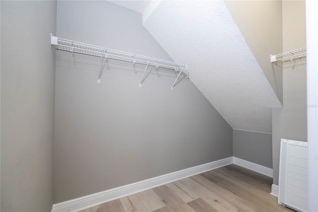 spacious closet with wood-type flooring and lofted ceiling