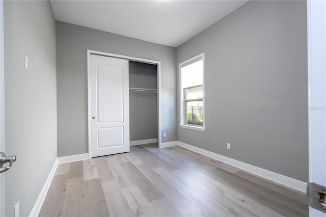 unfurnished bedroom featuring light hardwood / wood-style flooring and a closet