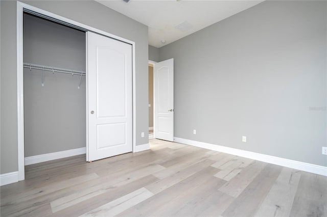 unfurnished bedroom featuring light hardwood / wood-style floors and a closet