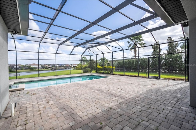 view of swimming pool featuring glass enclosure, a water view, and a patio