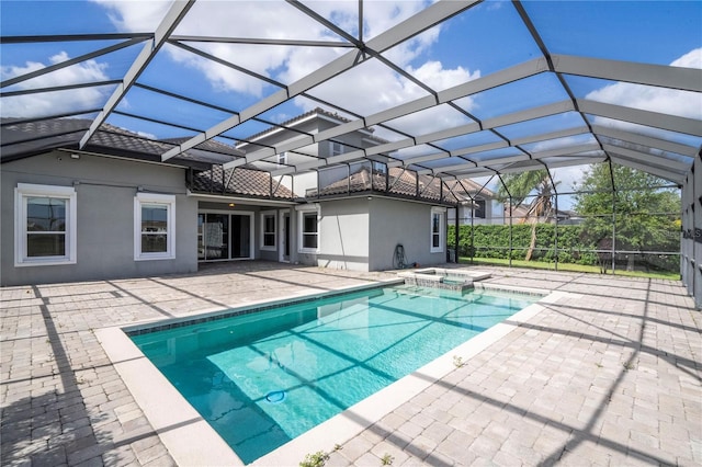 view of pool with glass enclosure, an in ground hot tub, and a patio area