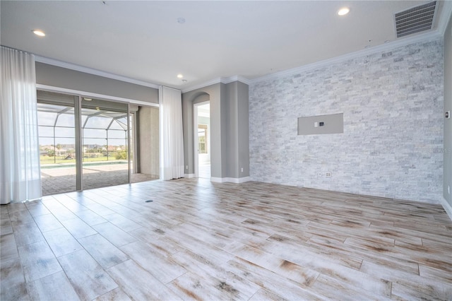 spare room with light hardwood / wood-style flooring and crown molding