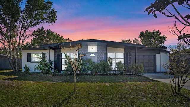 view of front of property featuring a lawn and a garage