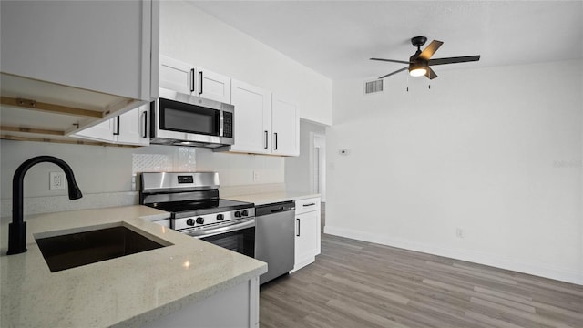 kitchen featuring light hardwood / wood-style floors, stainless steel appliances, light stone counters, white cabinets, and sink