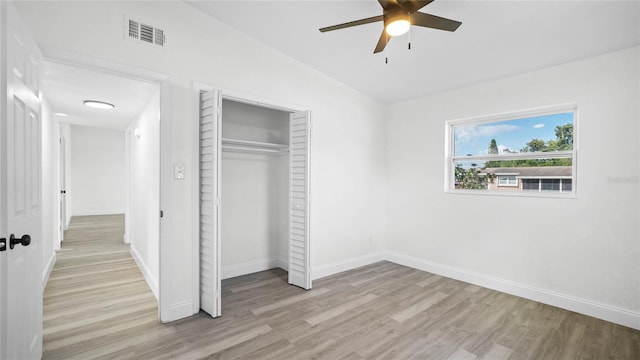 unfurnished bedroom featuring a closet, lofted ceiling, ceiling fan, and light hardwood / wood-style flooring