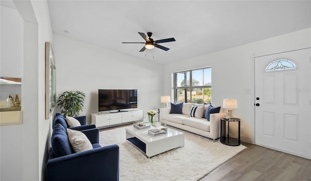 living room featuring wood-type flooring and ceiling fan