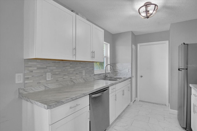 kitchen with white cabinets, a textured ceiling, stainless steel appliances, and sink