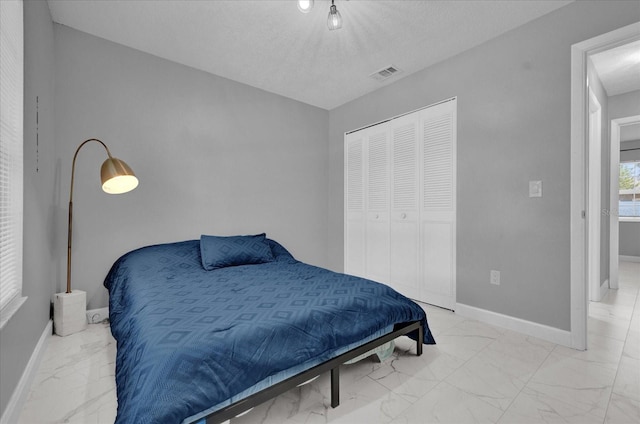 bedroom featuring a textured ceiling and a closet