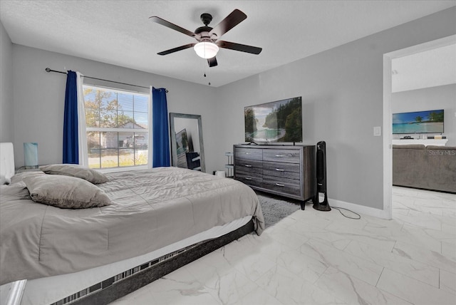 bedroom with ceiling fan and a textured ceiling