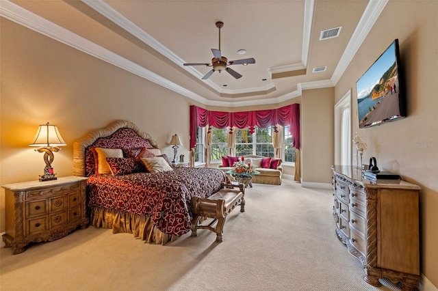 carpeted bedroom with ceiling fan, ornamental molding, and a tray ceiling