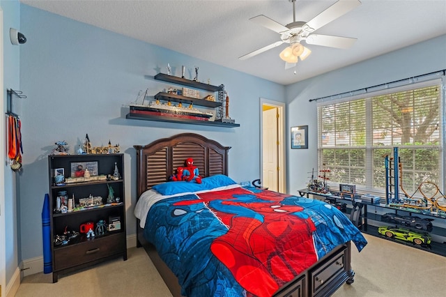 bedroom featuring light carpet, a textured ceiling, and ceiling fan