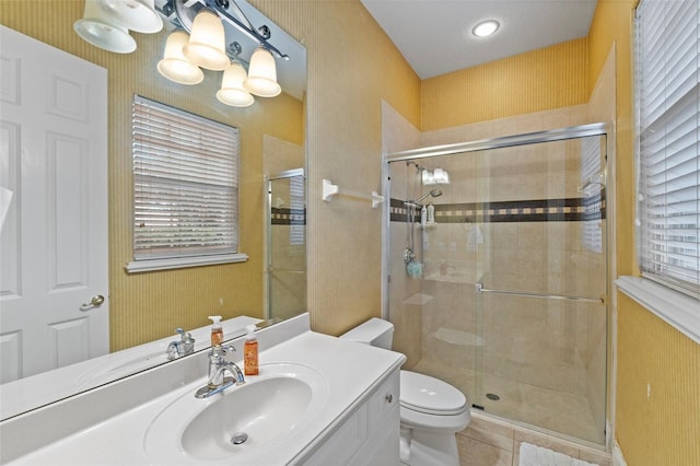 bathroom with tile patterned floors, vanity, an enclosed shower, and toilet