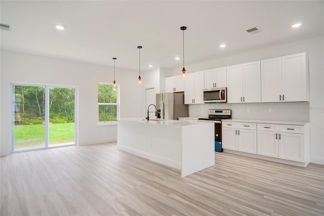 16270 SW 29th Court Rd, Ocala, FL 34473 - kitchen featuring appliances with stainless steel finishes, light wood-style floors, light countertops, an island with sink, and recessed lighting