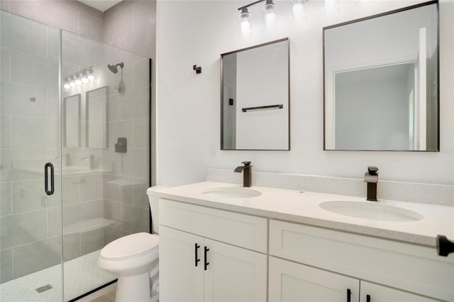 bathroom featuring toilet, vanity, and an enclosed shower