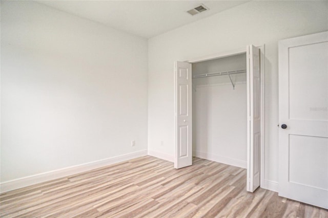 unfurnished bedroom featuring light hardwood / wood-style flooring and a closet