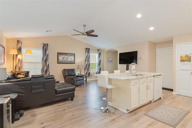 kitchen featuring dishwasher, a breakfast bar, sink, white cabinetry, and a kitchen island with sink