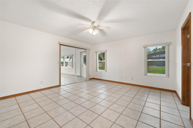 tiled spare room featuring ceiling fan and a textured ceiling