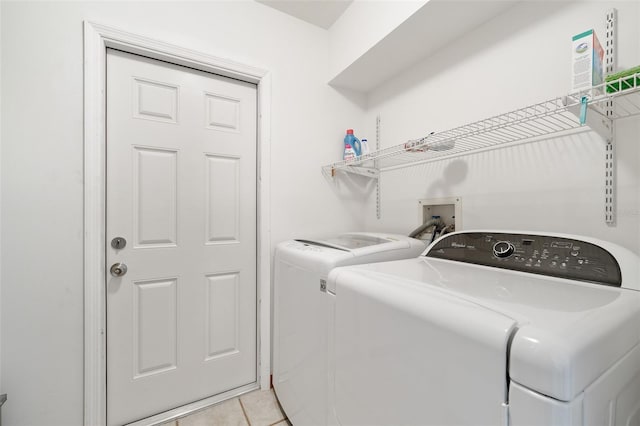 clothes washing area featuring separate washer and dryer and light tile patterned floors