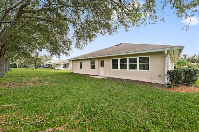 rear view of property featuring a yard