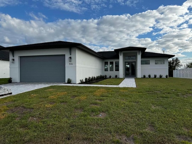 view of front of home with a front yard and a garage