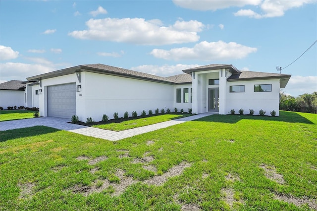 prairie-style home featuring a front lawn and a garage