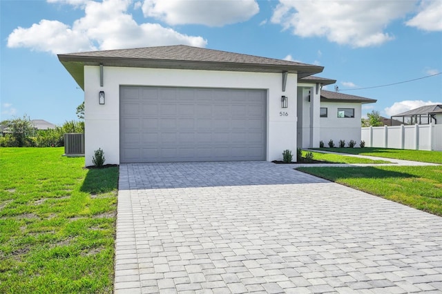 view of front facade featuring a front lawn, a garage, and central AC unit