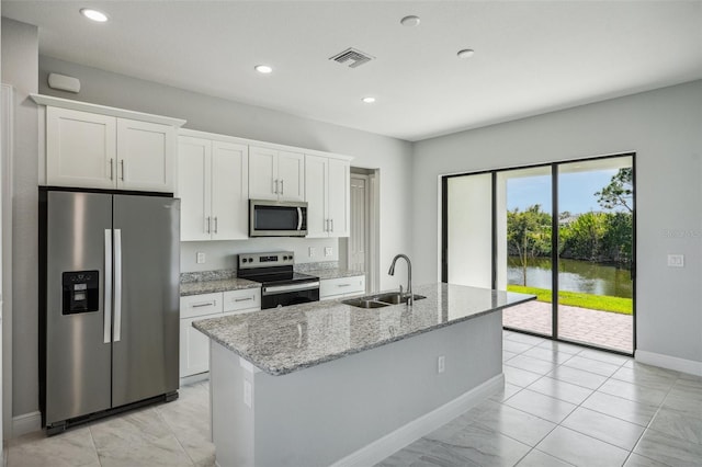 kitchen with white cabinets, appliances with stainless steel finishes, a water view, and sink