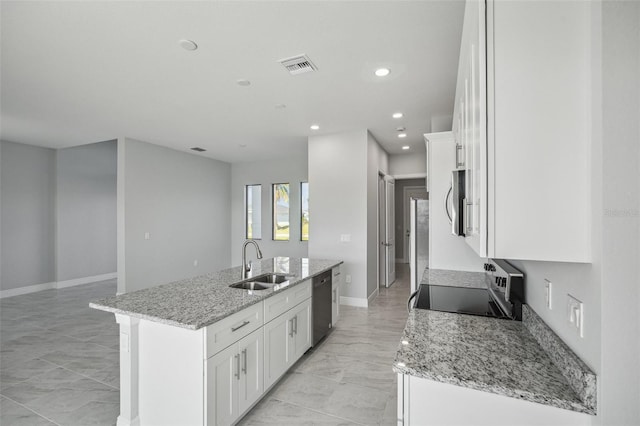 kitchen with a center island with sink, sink, stainless steel dishwasher, light stone counters, and white cabinetry