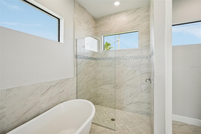 bathroom with separate shower and tub and tile walls