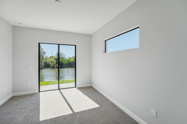 empty room featuring light carpet and a water view