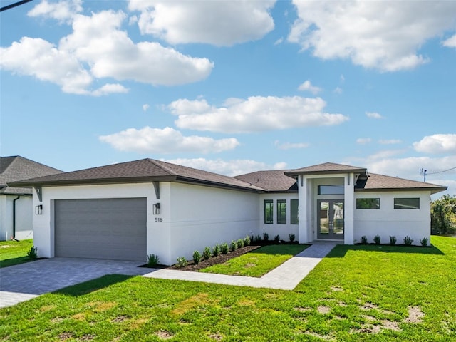 prairie-style home featuring a front yard, french doors, and a garage