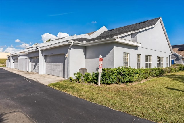 view of property exterior featuring a garage and a lawn