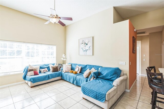 living room with a textured ceiling, tile patterned flooring, and ceiling fan