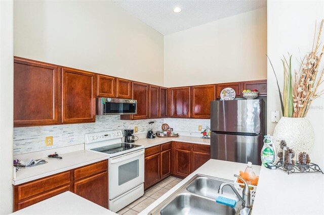 kitchen with appliances with stainless steel finishes, tasteful backsplash, light tile patterned floors, and sink