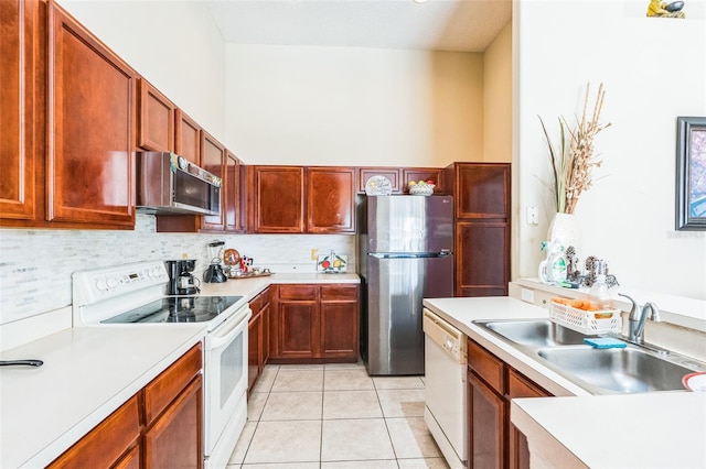 kitchen with stainless steel appliances, light tile patterned flooring, sink, and backsplash