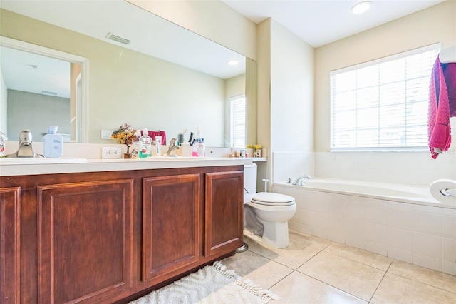 bathroom with vanity, a healthy amount of sunlight, tile patterned floors, and a relaxing tiled tub