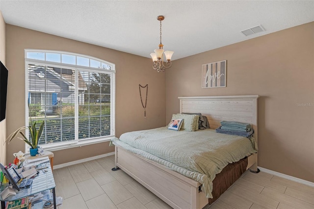 bedroom with a textured ceiling and a notable chandelier