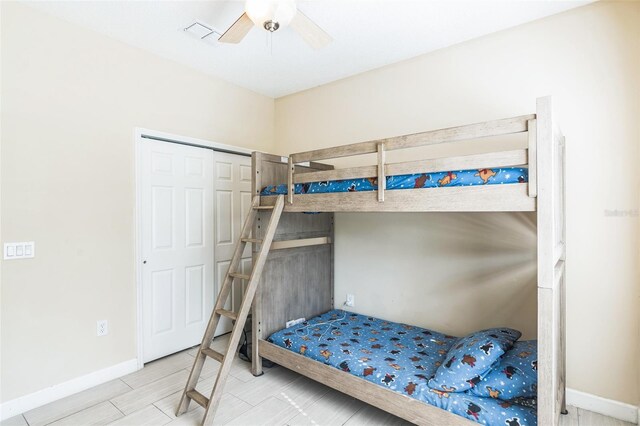 bedroom featuring hardwood / wood-style floors, ceiling fan, and a closet