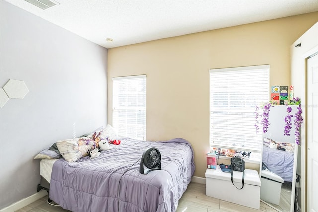 bedroom featuring light hardwood / wood-style floors and a textured ceiling