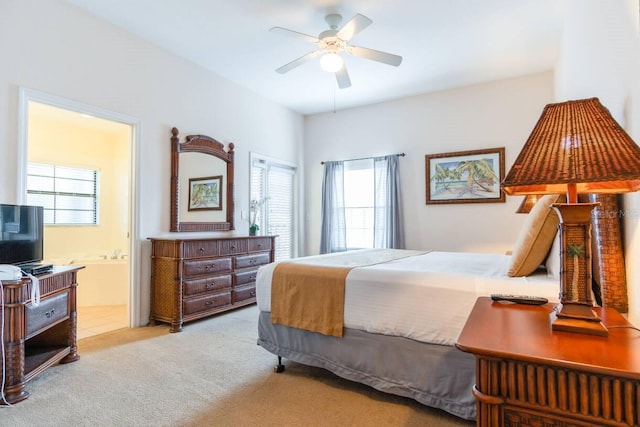 bedroom with light carpet, ceiling fan, and ensuite bath